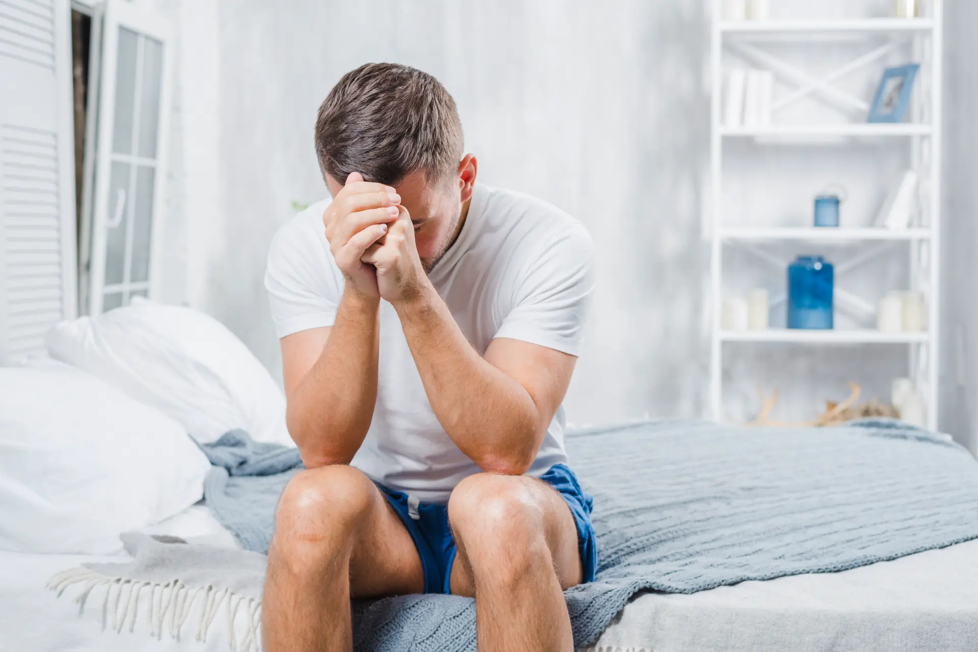 frustrated-man-with-headache-sitting-bed-home